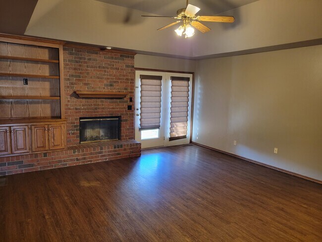 Fireplace and bookshelf in the living room with vinyl floors - 921 Blue Ridge Dr