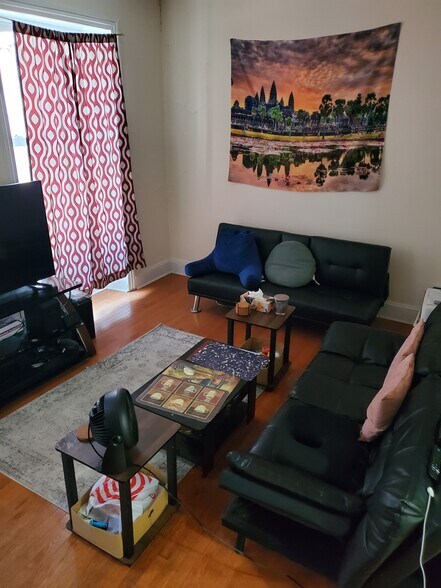 Large and bright living room with hardwood floors and tall historic windows - 112 S 20th St