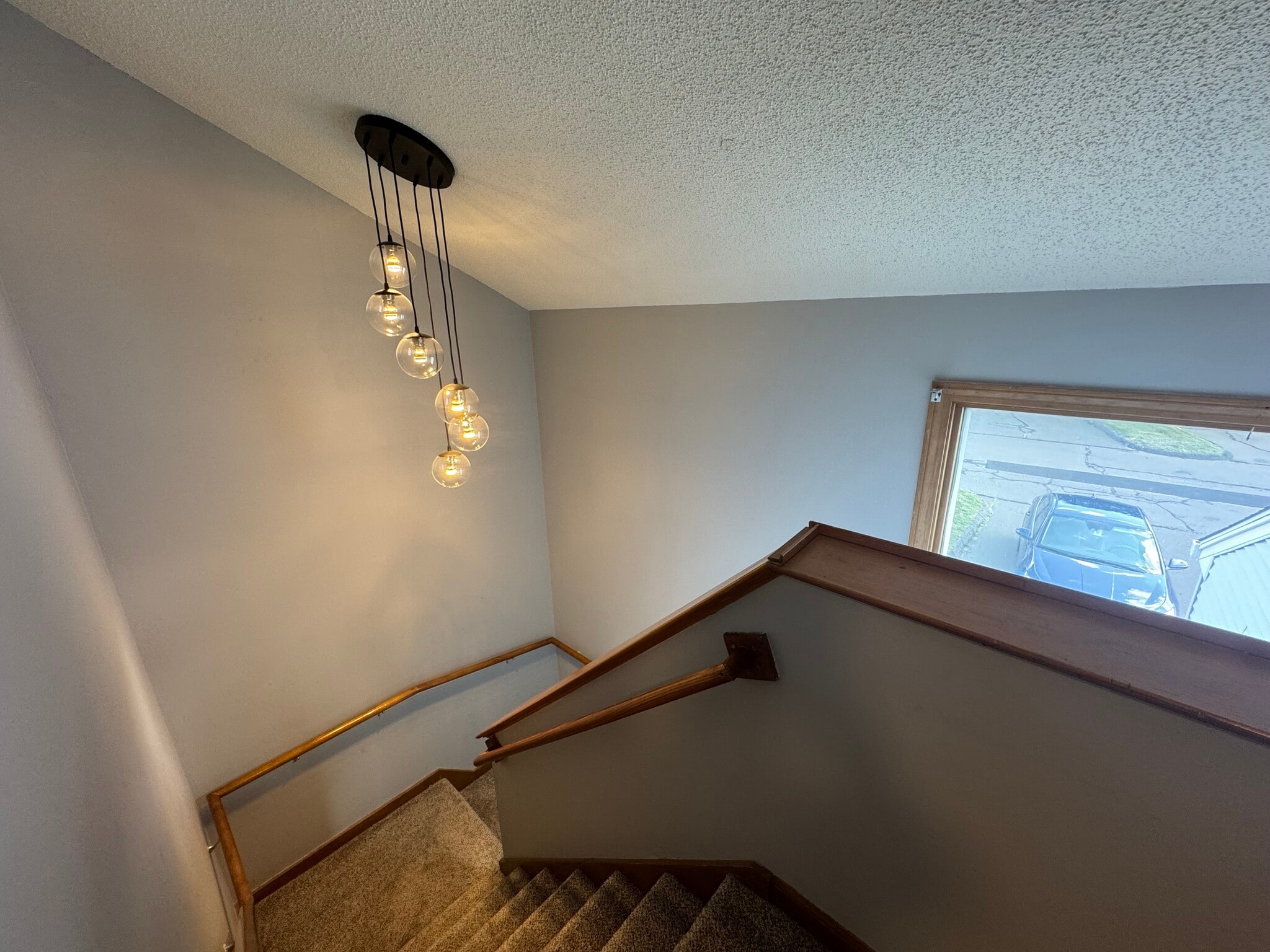 Carpeted stairway and landing with modern light fixture and lots of natural light - 705 Lake Ave