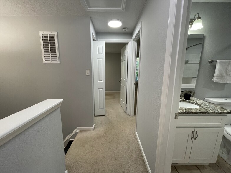 Hallway leading to additional two bedrooms. Right - hallway bath. Left - linen closet with bright li - 4204 Whistler Ct