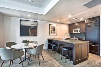 City Home kitchen featuring granite countertops and espresso cabinetry - The Bravern