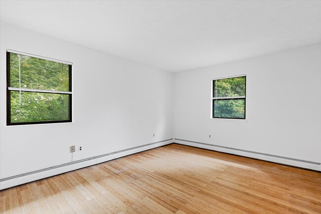 Bedroom with space for a queen-size bed, featuring two closets and windows. - 45 High St