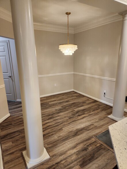 Living room with pillars, custom chandelier. Chair rail. - 5559 glenridge dr,