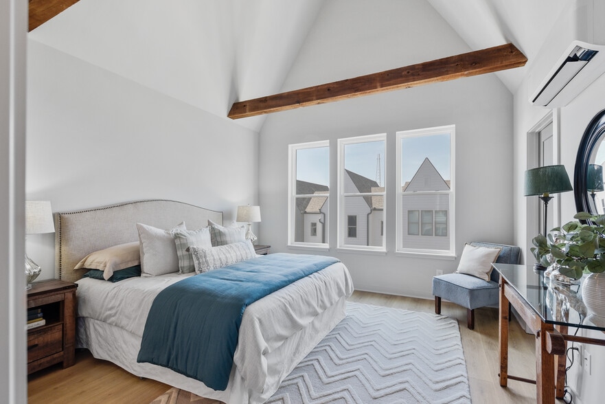 Striking master bedroom with vaulted ceilings, exposed wood beam, and an abundance of natural light. - 358 E Village Ln