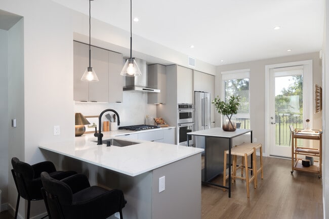 Signature Collection I 3-Bedroom Townhome Kitchen with upgraded stainless steel appliances, pendant lighting, and undercabinet lighting - Avalon Pleasanton