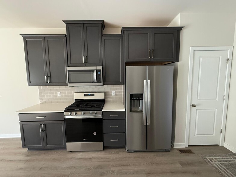 The kitchen is well-appointed with 42" cabinets in Pewter Maple color with crown molding, stylish wh - 3 Shamrock Cir