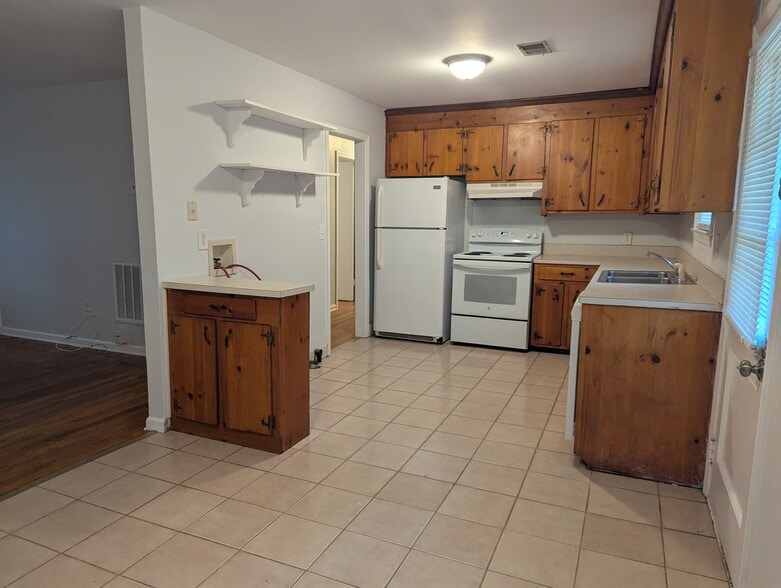 Eat-in kitchen and dining area with durable tile flooring, refrigerator, and doorway to the living s - 1527 Brookbank Ave