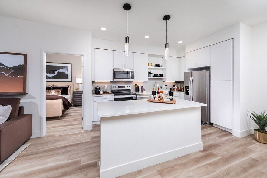 Kitchen with prep island and light wood style flooring - Marlowe South Las Vegas