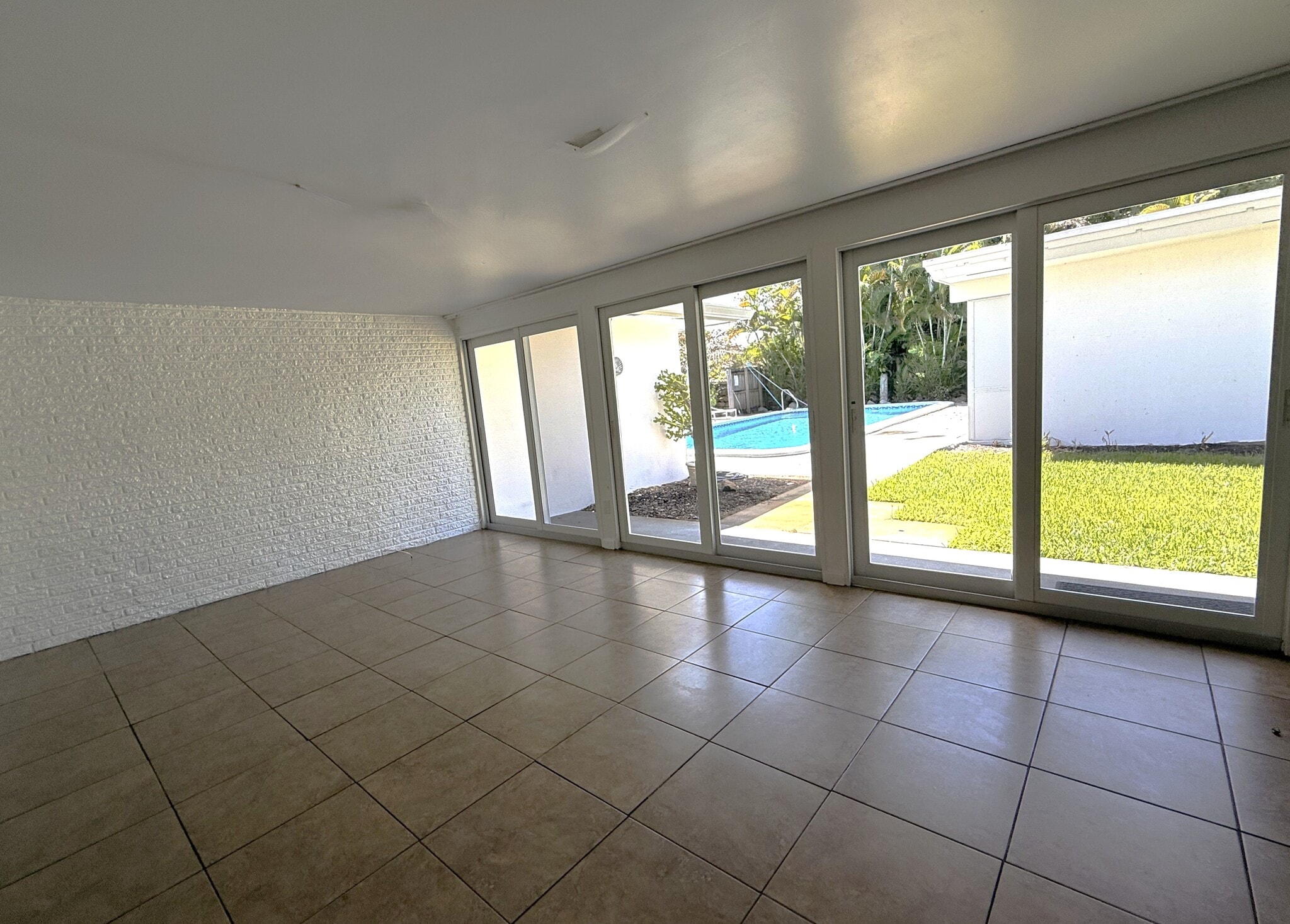 Sunroom without furniture overlooking Poo - 602 NE 37th St