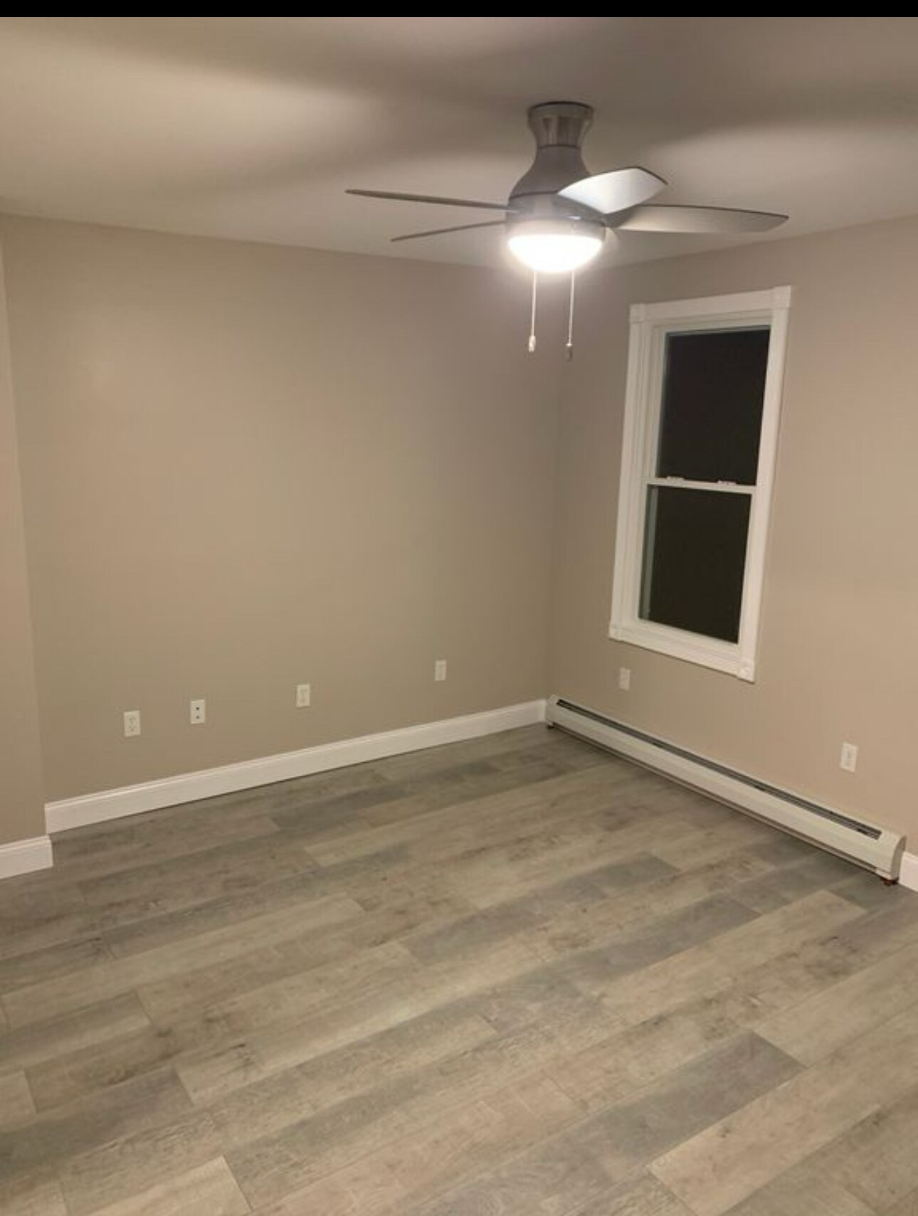 Living room with ceiling fan and door to front entrance and porch. - 1744 Farmington Ave