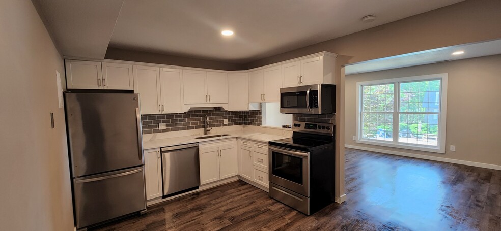kitchen with all stainless appliances with brand new quartz countertops and glass tile backsplash - 1100 E 6th St