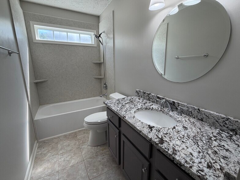 Upper level hall bath with updated granite top, lighting and mirror - 6419 Woodmont Rd