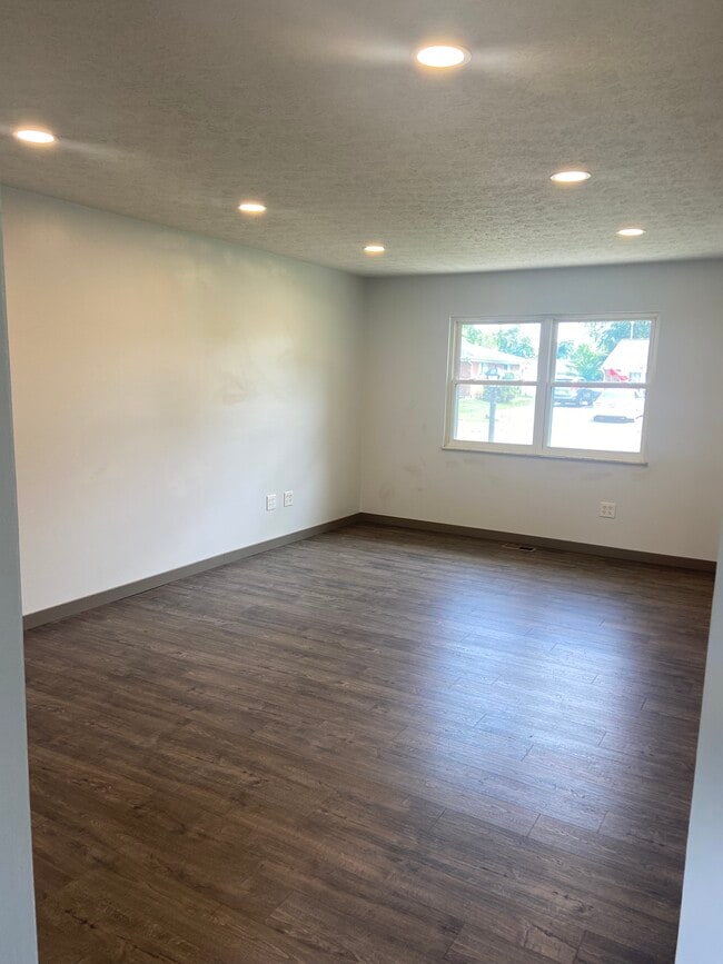 Living room with recessed lighting looks out at front yard - 174 Brisbane Ave