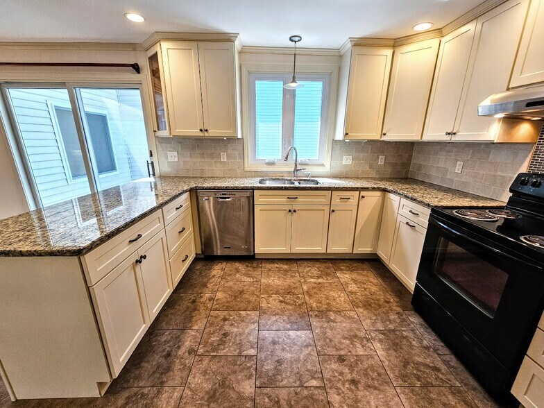 Kitchen with granite counter tops, dishwasher, electric stove, pull out storage in cabinets - 30 Fairfield Ave