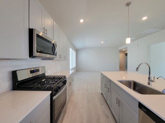 Building Photo - Single-story layout features a bright, open concept living area, dining space, and kitchen. Pebbl...