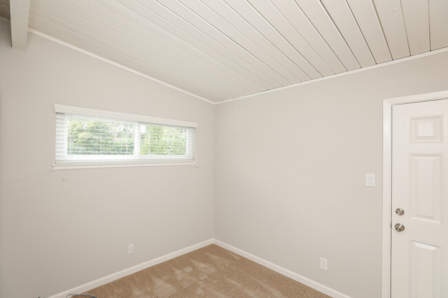 Front bedroom with vaulted ceilings, double pane window, newer carpet & access to rear patio - 3321 Alma St