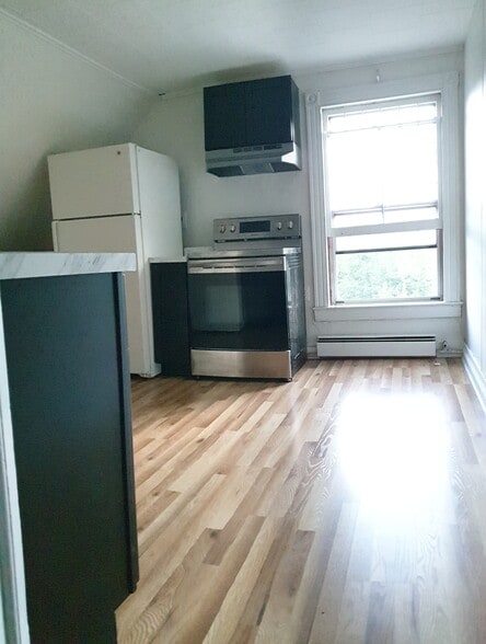 Sunlight fills this beautiful kitchen featuring abundant cabinets, new appliances, and a modern look - 412 Morris Ave