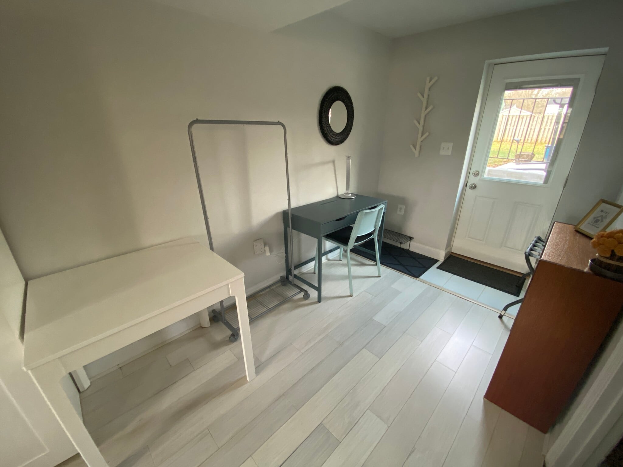 Table, additional clothes hanging space, desk, and private entrance from the backyard. - 7922 Fitzroy St