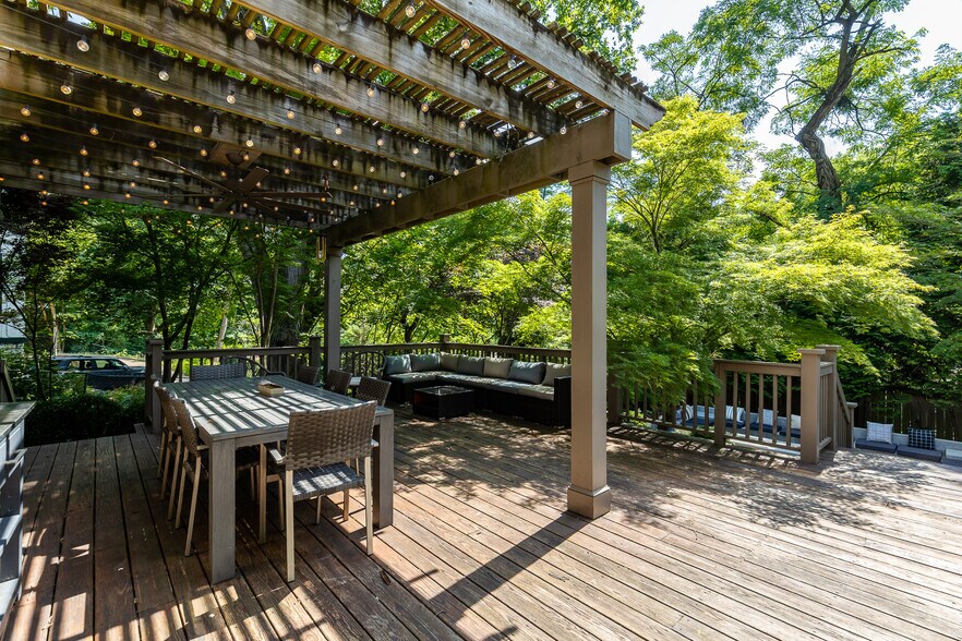 Large outdoor deck area with lush landscaping. - 4061 Beechwood Ave