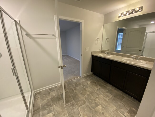 Master bath with double sink across from walk-in shower and showing access from master bedroom - 9010 Fenton Rd.