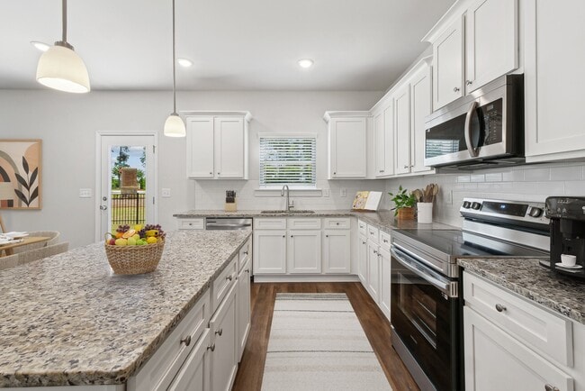 A view of the spacious kitchen and stainless steel appliances - Alma Farms