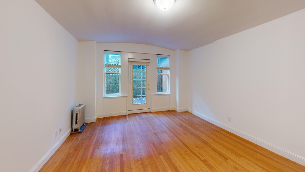 Sunlit room with a large window and wood-like flooring - 645 Stockton Street