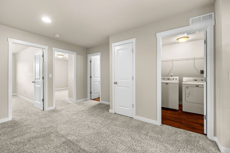 Upstairs landing showing doors to bedrooms 1 and 2, hall bathroom, storage, and laundry room - 108 NE 14th St