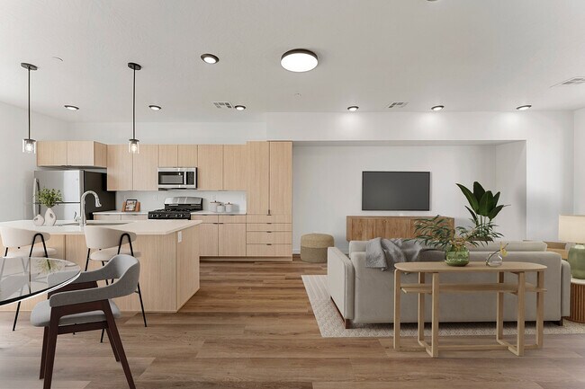 Modern open-concept kitchen and living room with sleek light wood cabinetry, an inviting island, cozy seating, and elegant decor. - Coal Creek Townhomes