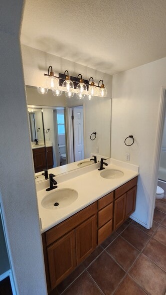Master bath dual vanity with new lighting and hardware - 16939 Robins Nest Way