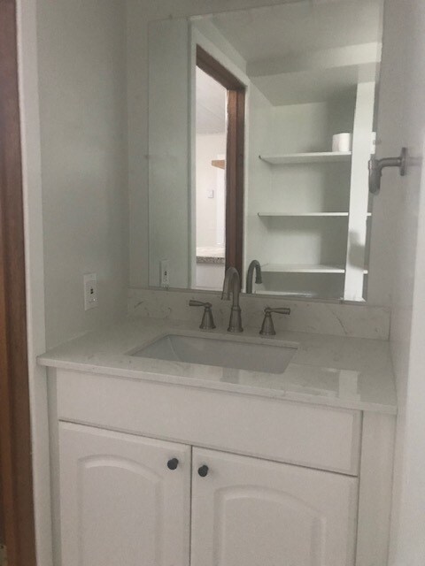 Bathroom sink with wall shelving behind - 1303 44th Ave SW