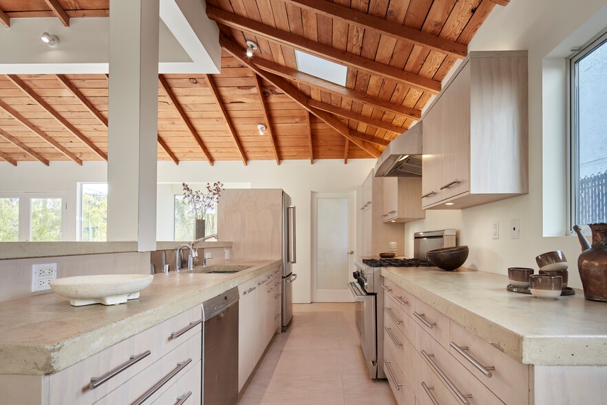 open stainless steel kitchen with polished concrete countertops - 703 Palms Blvd