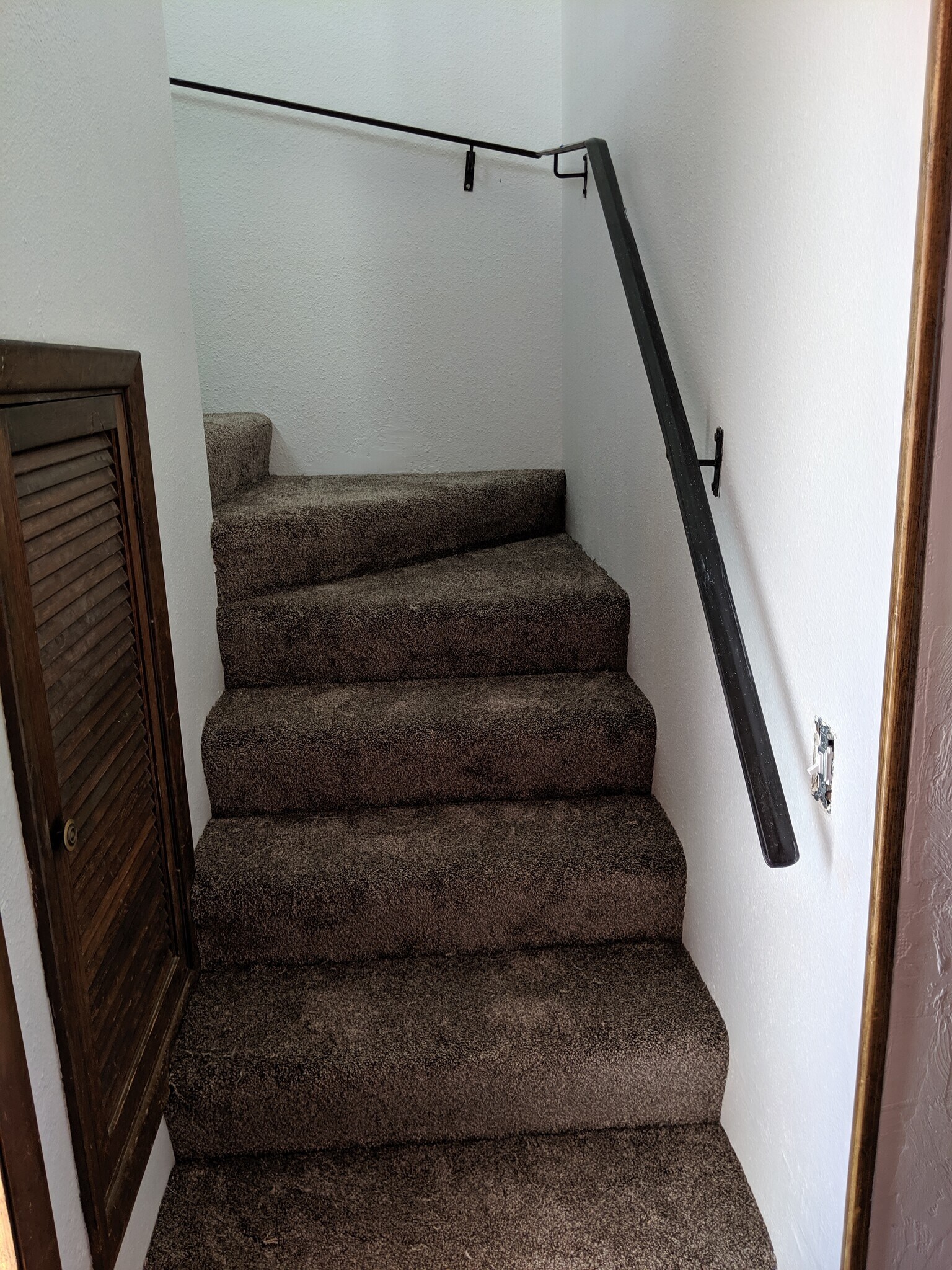 Stairs from the bottom. Access door to the under stair storage area shown on the left. - 2115 Pleasanton St