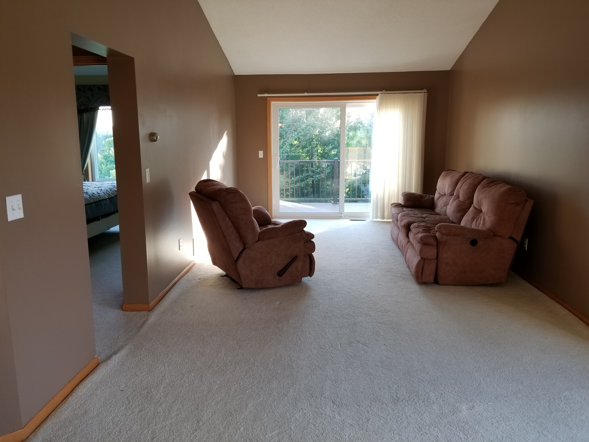 Living room with patio door leading to maintenance-free deck - 9719 Xenium Lane N