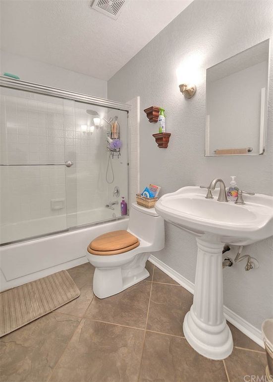 Guest full bathroom with tub and shower enclosure and mirrored medicine cabinet - 1073 S Romney Dr