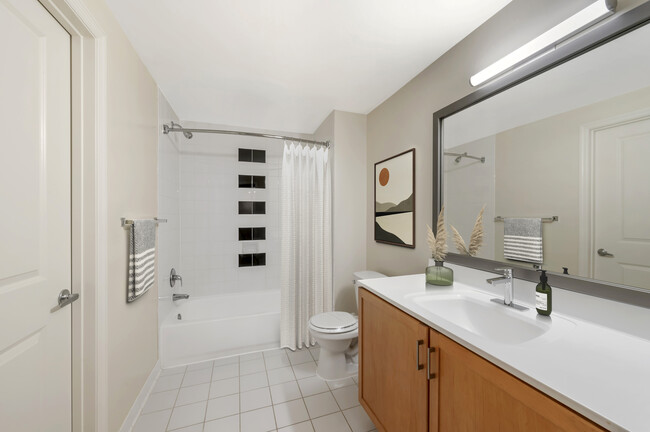 Updated Finishes bath with white laminate countertops, oak cabinetry, and hard surface flooring - Kanso Silver Spring