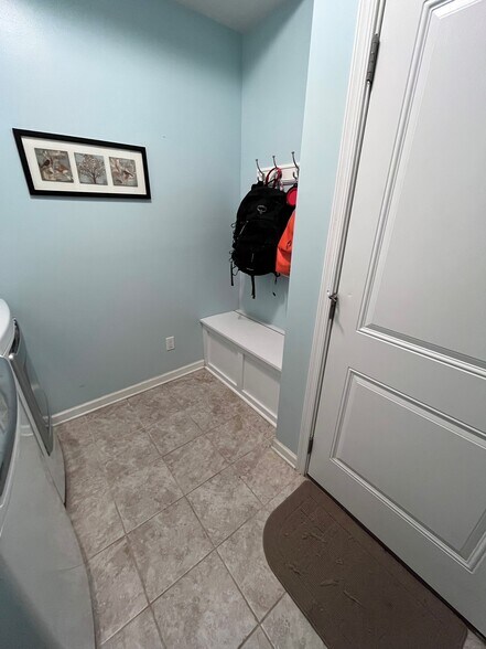 Laundry room with cabinets above washer/dryer, mudroom bench and hooks - 7736 Tranquil Trl
