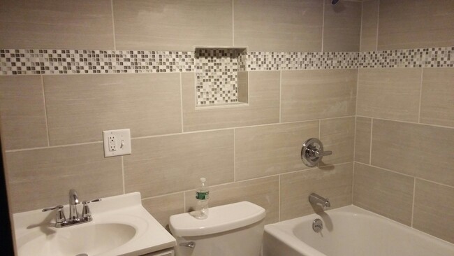 tiled bathroom with tub - second bathroom in unit - 318 Pleasant St