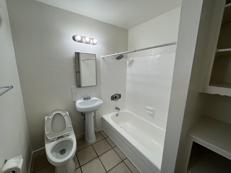 Bathroom sink, toilet, and shower and tub. - 207 S Lillie Ave