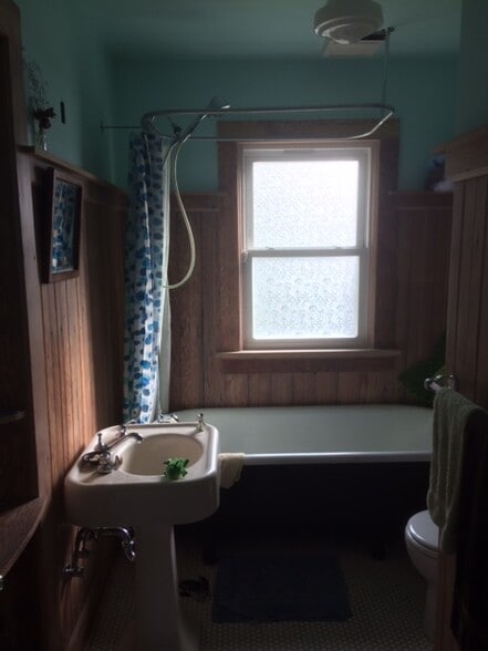 Lovely bathroom with new toilet, tile floor and wood paneling. - 8950 NE Emerson St
