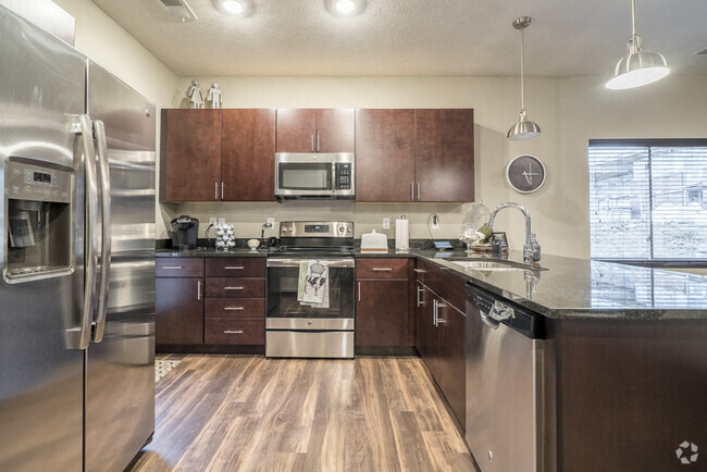 Our traditional design scheme features rich, dark cabinetry with darker granite countertops. - The Villas at Falling Waters