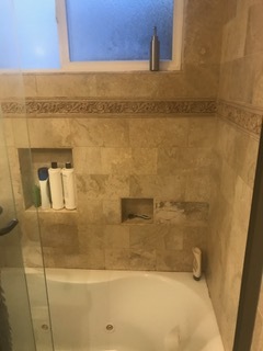 Built-in shampoo shelf and soap dish in the marble tiled bathroom. - 1857 Pandora Ave