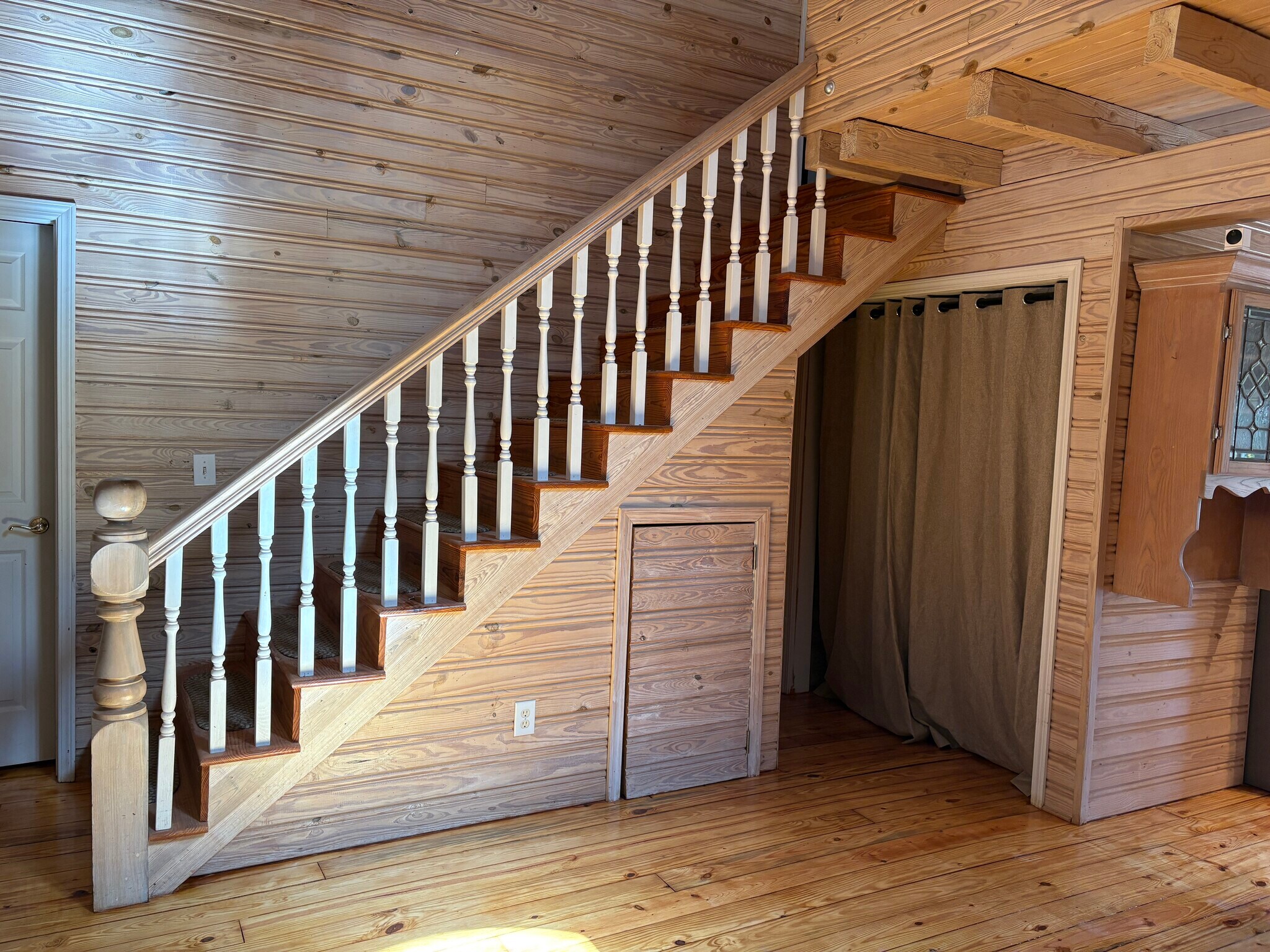 Stairs in living room with storage underneath and washer dryer hookups behind curtain - 86 Yonah Vw