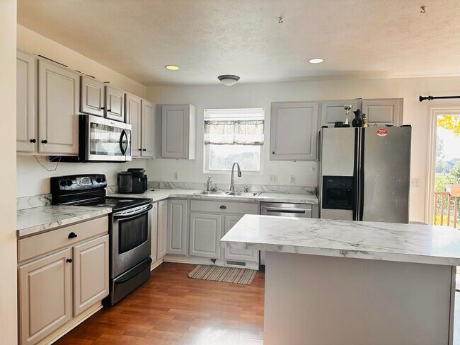 A freshly renovated kitchen featuring brand-new countertops and a fresh coat of paint - 4555 Cider Wood Dr NW