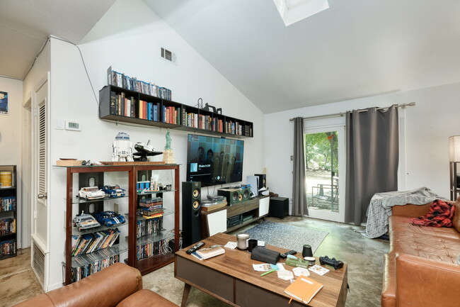 Living room with vaulted ceiling and skylight, sliding door to private back yard - 1602 Valleyridge Dr