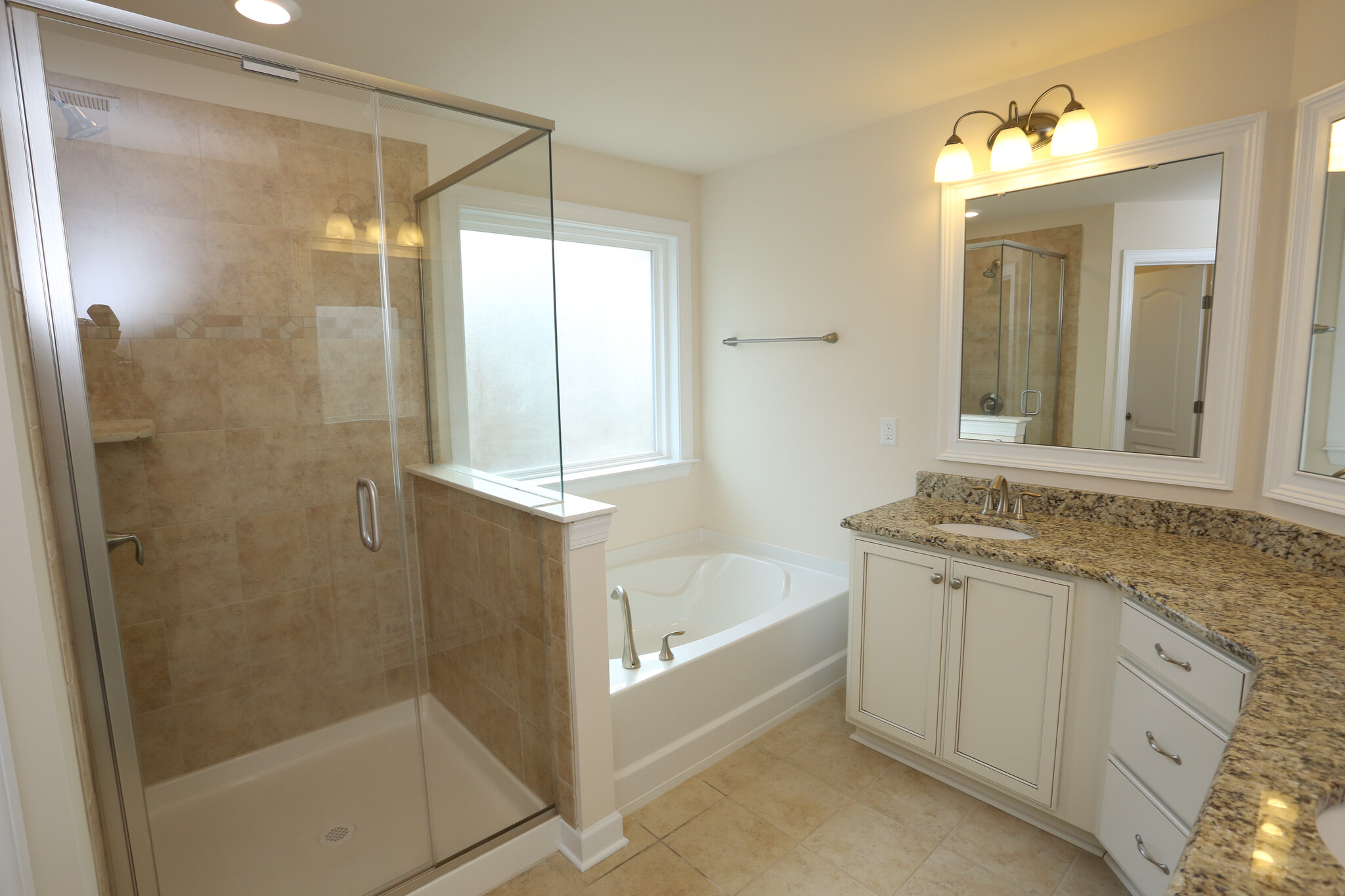 Primary bath with large shower, soaking tub, and dual vanities. - 2001 Trading Path Lane