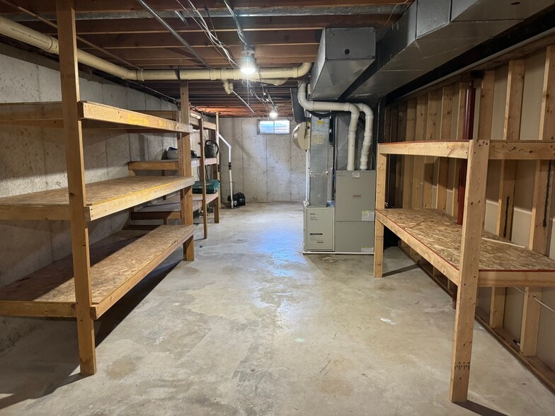 Unfinished half of basement with built in shelving for storage. - W2038 County Road WH