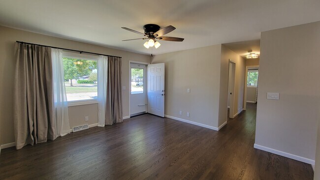 Large Living Room with refinished hardwood floors through the first floor. New ceiling fan & drapes - 6305 49th Ave