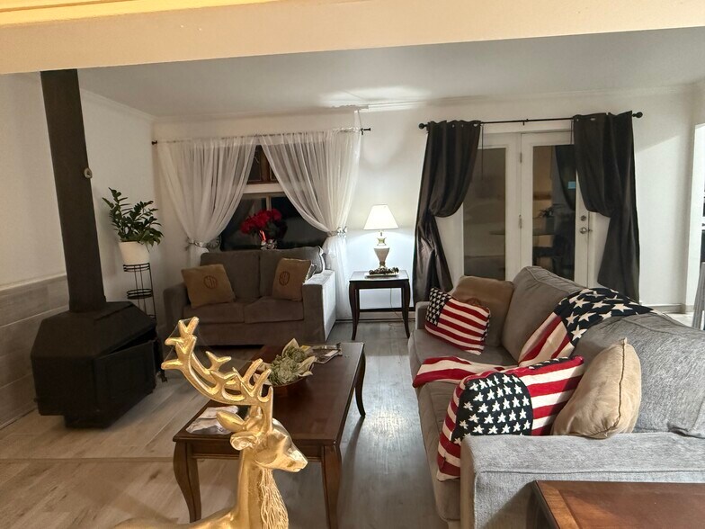 Living area with wood stove burning fireplace. - 1053 Danby Rd