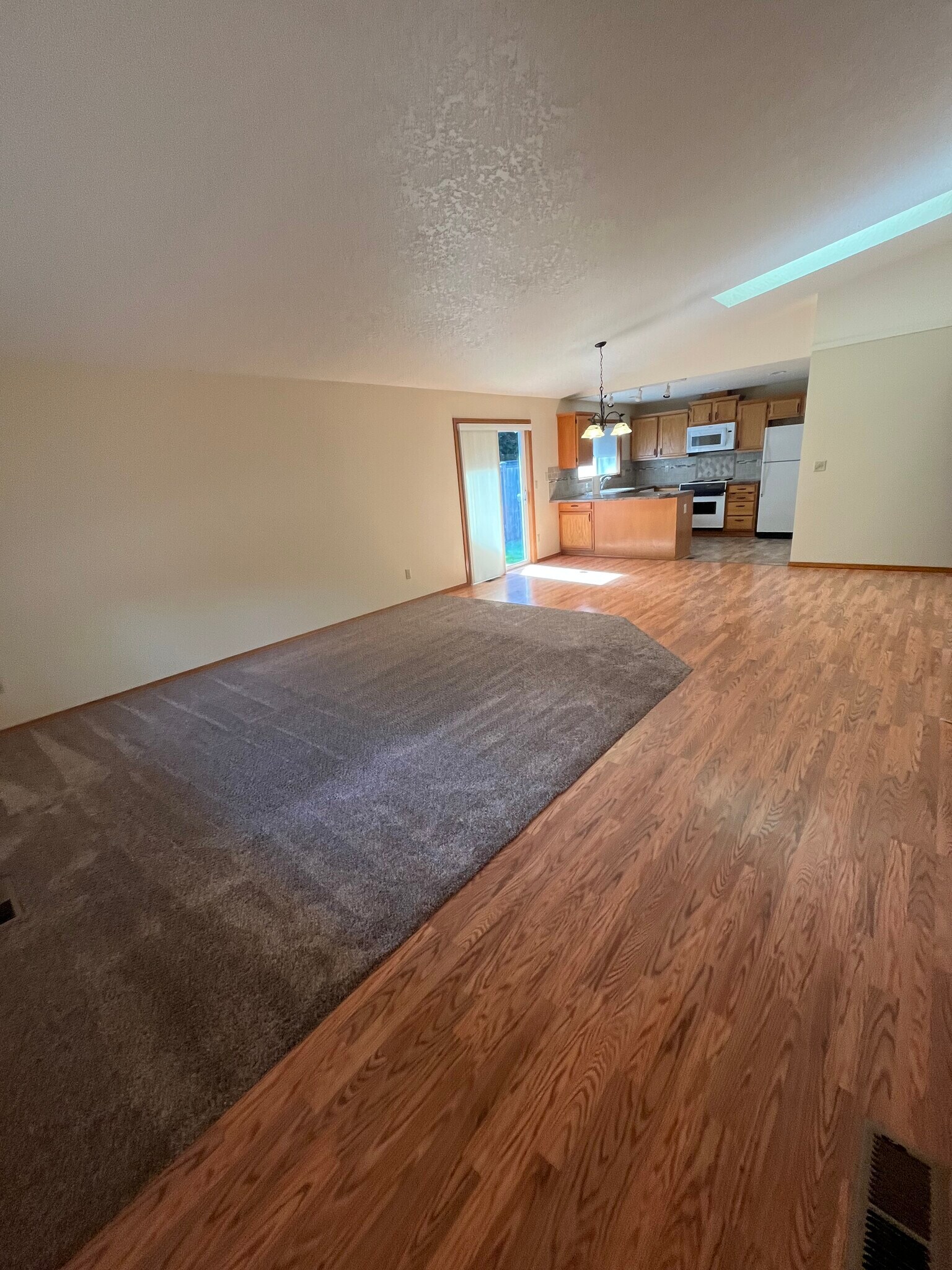 Great room, living room dining room kitchen with vaulted ceilings and skylight - 15354 SW Clifford Ct