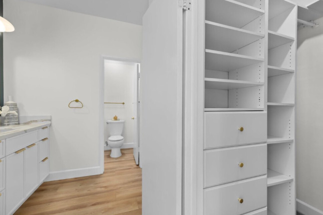 The deep 5-ft x 5-ft walk-in closet has shelves, drawers, long hanging rods, and luggage storage. - 2221 Ocean Ave